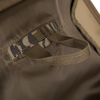 Close-up of the Hardline Blind Bag showing heavy-duty fabric with webbing loops and a carry strap, designed for enduring wet, harsh hunting conditions.