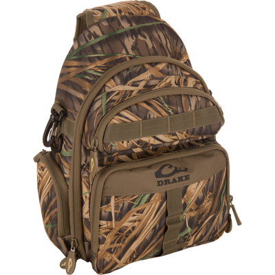 Hardline Sling Pack in camo with multiple zippered compartments and webbing, featuring Drake's logo, built for durability and weather resistance in outdoor activities.