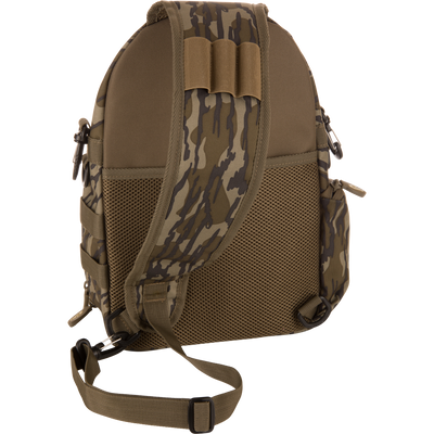 Hardline Sling Pack, back view, showing padded mesh panel, adjustable strap with quick-release buckles, webbing loop, carry handle, and nylon straps for gear attachment.