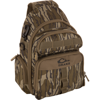 Hardline Sling Pack with tiger-stripe camouflage, featuring rugged nylon, zippered pockets, MOLLE webbing, and D-ring, branded “Drake” for versatile outdoor or everyday use.