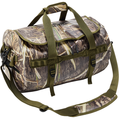 Waterproof Duffel Bag with marsh-grass camouflage, olive-green handles, adjustable strap, attachment loops, and compression straps, designed for outdoor and hunting gear storage.