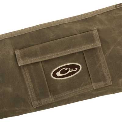 Close-up of the Wax Cotton Gun Sleeve, showcasing its khaki wax canvas, stitched edges, flap pocket, and embroidered logo, designed for shotgun protection and convenience.