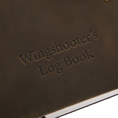 Drake Leather Wingshooter's Hunting Log close-up, showcasing embossed title and durable full-grain leather cover with visible white page edges at the bottom.