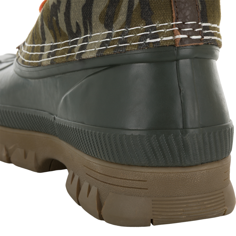 Close-up of the Throwback 80 Waxed Canvas Lace Up Duck Boot, highlighting its camouflage-patterned fabric upper, chunky brown lug tread, and dark green molded rubber heel.