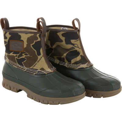RTL - Throwback 80 Waxed Canvas Slip On Duck Boot with camouflage canvas, leather trim, waterproof rubber shell, and lugged outsole for durability and traction.