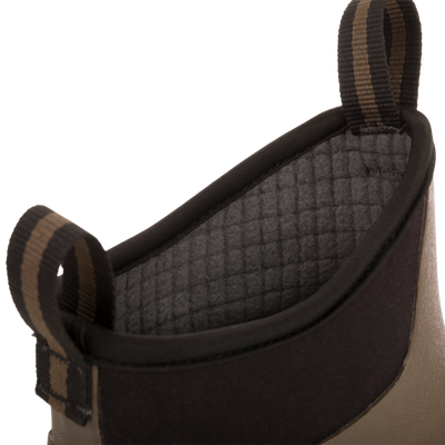 Camp Deck Boot close-up: neoprene cuff with quilted grey lining, striped pull-loops, and tan/olive shell, showcasing waterproof design for outdoor adventures.