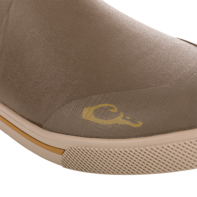 Close-up of Camp Deck Boot toe, showcasing the textured waterproof neoprene upper, molded rubber sole with tread, and visible yellow logo above the sole.
