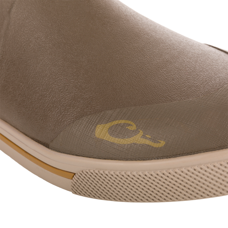 Close-up of Camp Deck Boot toe, showcasing the textured waterproof neoprene upper, molded rubber sole with tread, and visible yellow logo above the sole.