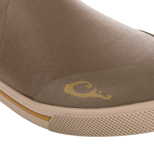 Close-up of Camp Deck Boot toe, showcasing the textured waterproof neoprene upper, molded rubber sole with tread, and visible yellow logo above the sole.