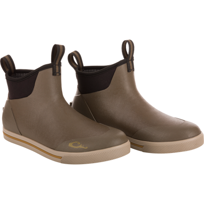 Camp Deck Boot featuring ankle-height design, olive rubber upper with black neoprene collar, and non-marking siped outsole for excellent traction on wet surfaces.