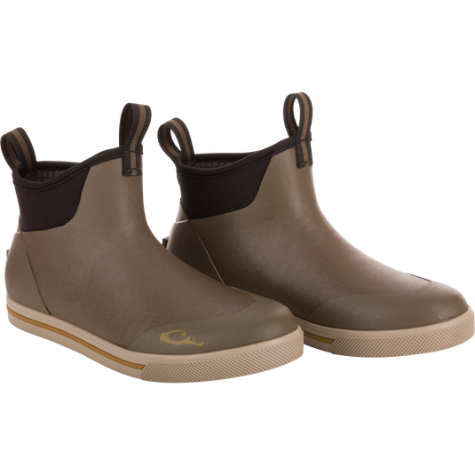 Camp Deck Boot featuring ankle-height design, olive rubber upper with black neoprene collar, and non-marking siped outsole for excellent traction on wet surfaces.