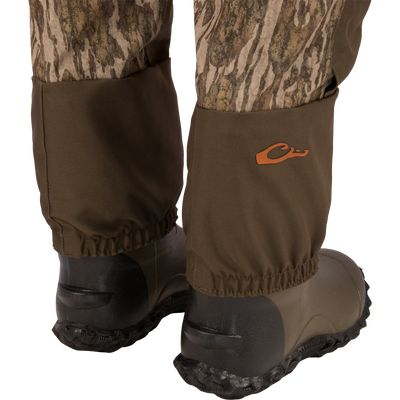 Hardline Insulated Breathable Wader shown with camouflage trousers tucked into brown gaiters over rugged rubber boots, highlighting waterproof and insulated features for outdoor adventures.