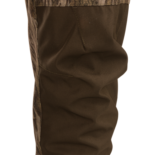 Close-up of the Hardline Insulated Breathable Wader's reinforced knee panel, showing durable stitching and camo trim for enhanced articulation and protection in rugged outdoor conditions.