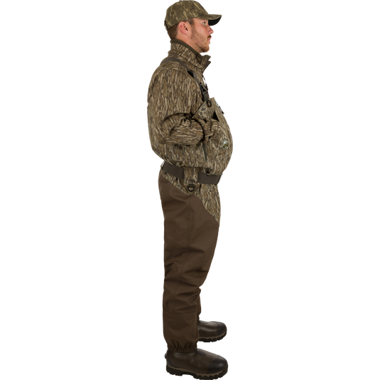 Uninsulated Guardian Elite HND Front Zip Waders - Realtree: A man in camouflage clothing wearing durable, waterproof waders with a front zipper, standing in the marsh.