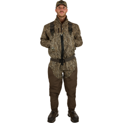 A man wearing the Guardian Elite Hybrid Insulated Front Zip Wader in a camouflage pattern, showcasing the durable, waterproof, and breathable hunting gear.