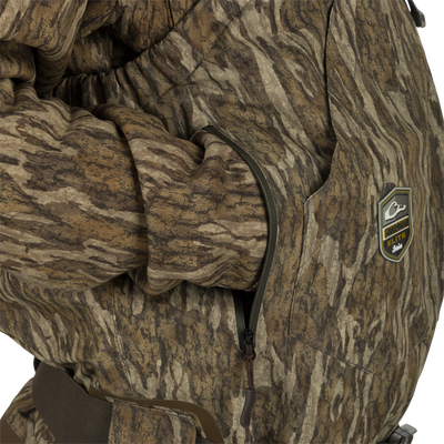 Person wearing the Insulated Guardian Elite HND Front Zip Wader, featuring camouflage design, reinforced seams, and Thinsulate® boot lining for cold weather hunting.
