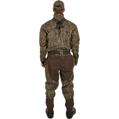 A man wearing the Uninsulated Guardian Elite Vanguard Breathable Waders, designed for extreme conditions, turned to the back.