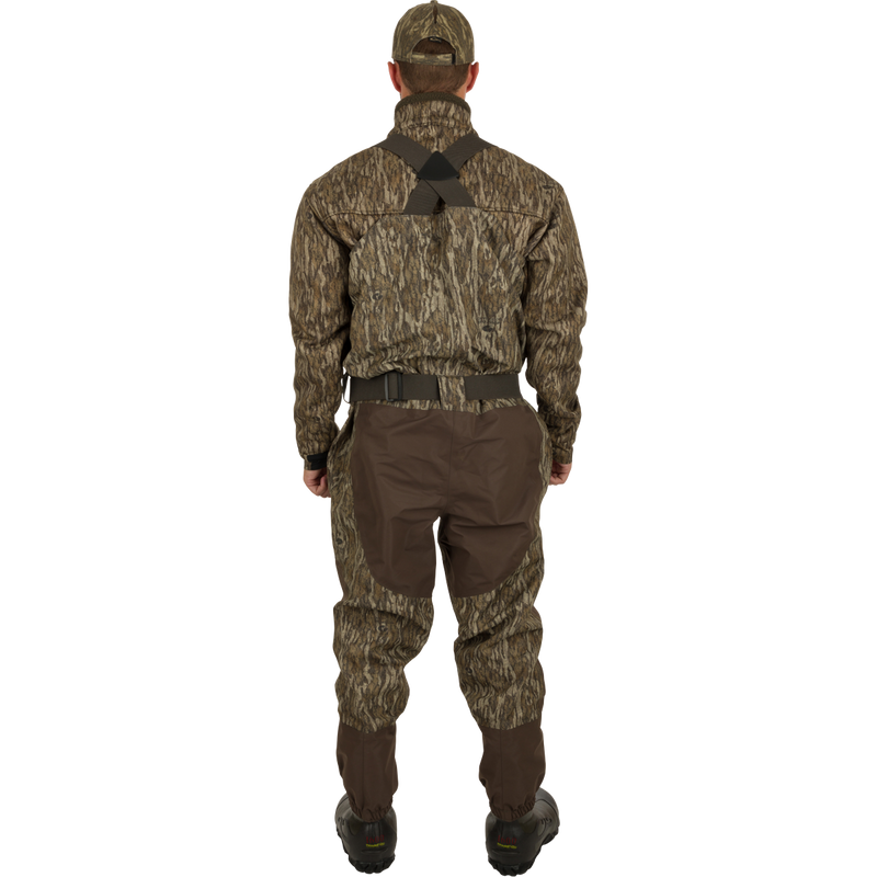 A man wearing the Uninsulated Guardian Elite Vanguard Breathable Waders, designed for extreme conditions, turned to the back.