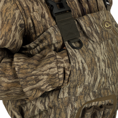 A person wearing Uninsulated Guardian Elite Vanguard Breathable Waders showcasing pass-through internal handwarmer pockets to keep your hands warm and protected on even the coldest days
