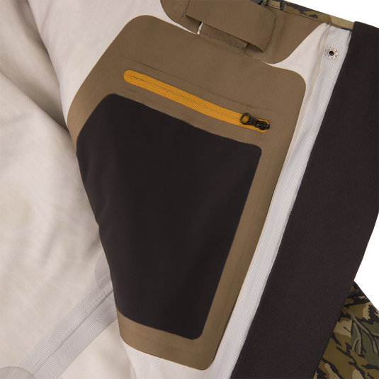 Inner panel of the BMF1600 Kevlar Wader with Primaloft, featuring off-white, tan, and black lining, yellow zip pocket, and camo fabric edge.