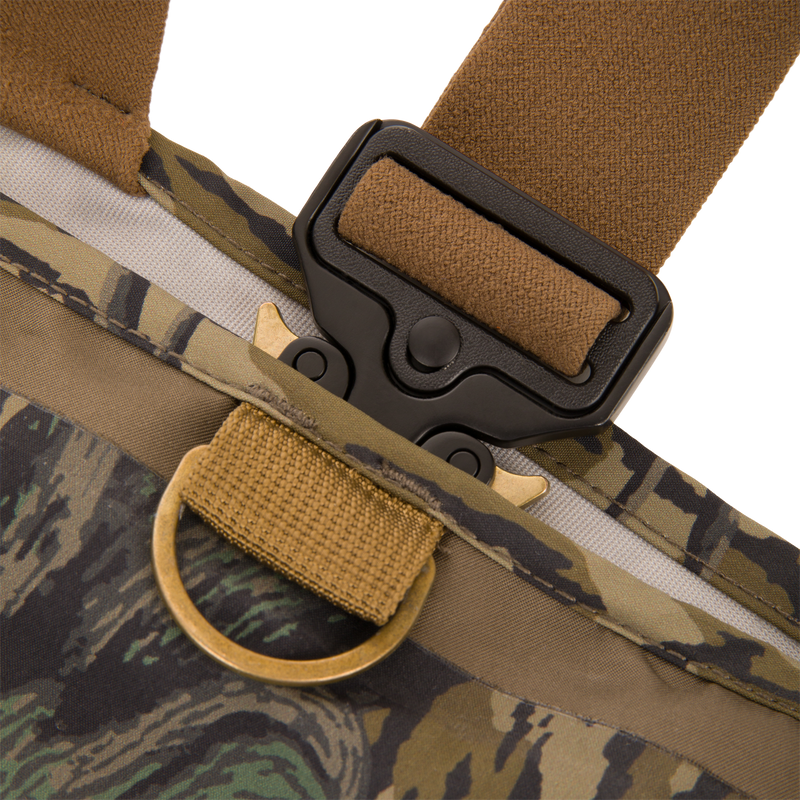 Close-up of BMF1600 Kevlar Wader with Primaloft, featuring a tan nylon webbing, black quick-release buckle, and brass D-ring on camouflage fabric.