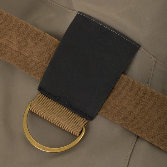 Close-up of a tan Kevlar wader belt from the Drake X Ducks Unlimited BMF1600 Kevlar Wader, featuring a black reinforced patch and an attached brass D-ring.