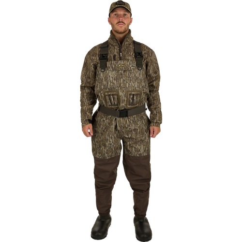 A man in camouflage uniform wearing Insulated Guardian Elite Vanguard Breathable Waders, standing confidently.