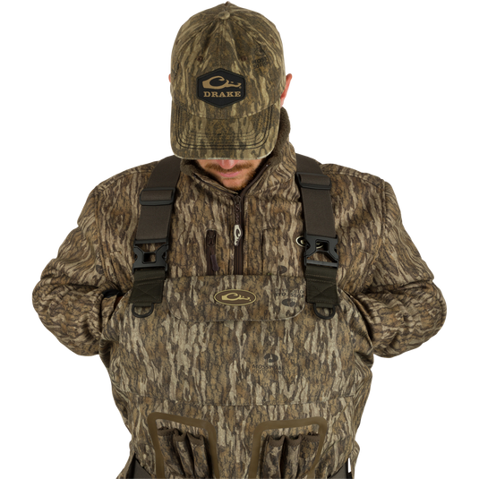 A man wearing Insulated Guardian Elite Vanguard Breathable Waders in camouflage clothing and hat, with a close-up of his face.