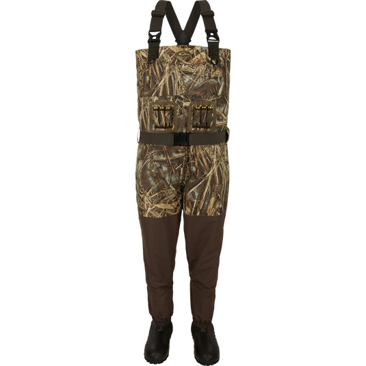 A product image of the Insulated Guardian Elite Vanguard Breathable Waders - Realtree. The image shows camouflage overalls with a belt and boots, along with a vest with a belt and bullets on it.