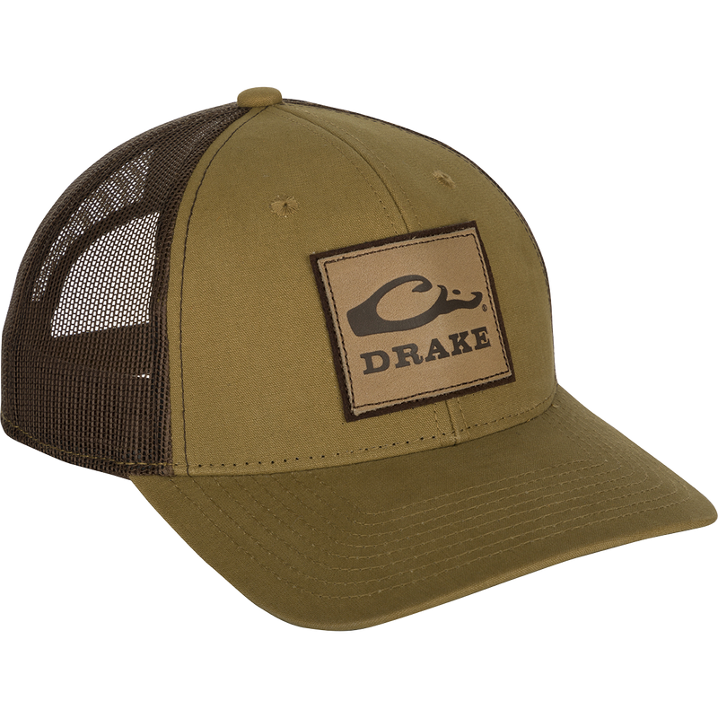 A weathered cotton/poly structured cap with a leather patch featuring the Drake Logo. Traditional trucker shape with a pre-curved visor and adjustable snapback closure. Comfortable and ruggedly handsome. From the Drake Logo Series.