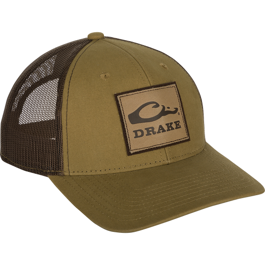A weathered cotton/poly structured cap with a leather patch featuring the Drake Logo. Traditional trucker shape with a pre-curved visor and adjustable snapback closure. Comfortable and ruggedly handsome. From the Drake Logo Series.