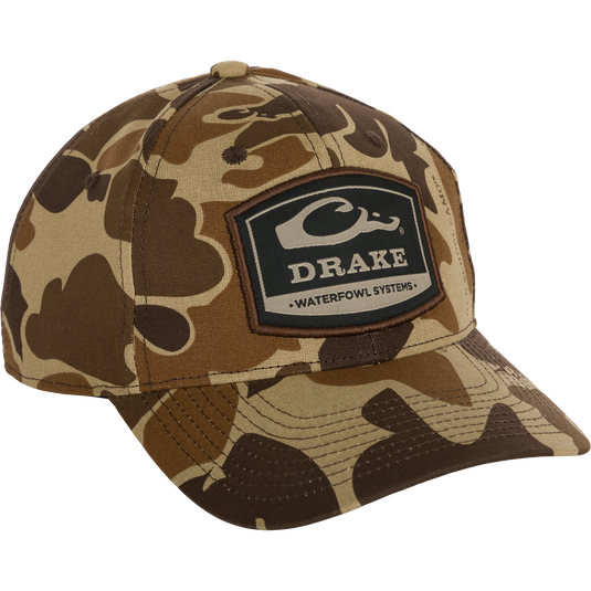 A 6-Panel Badge Cap with a camouflage design and logo, perfect for outdoor enthusiasts. Made of cotton blend panels, it offers a secure fit with a rear snap closure.