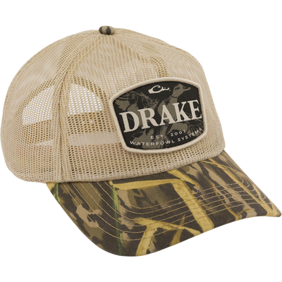Drake x Lost Hat Ea5y Meshed Trucker Cap featuring a camo-patterned bill, mesh back, and “DRAKE EST. 2002 Waterfowl Systems” logo patch on the front.