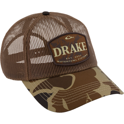 Drake x Lost Hat Ea5y Meshed Trucker Cap featuring a camouflage brim, mesh back, and adjustable snapback, ideal for outdoor and hunting activities.
