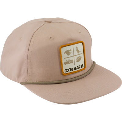 Tan Drake X Lost Hat DDTF Goat Rope Cap with a flat brim, a rope detail above the bill, and a square patch featuring four quadrants with a bird, a dog, a truck, and a football, with the word DRAKE underneath.