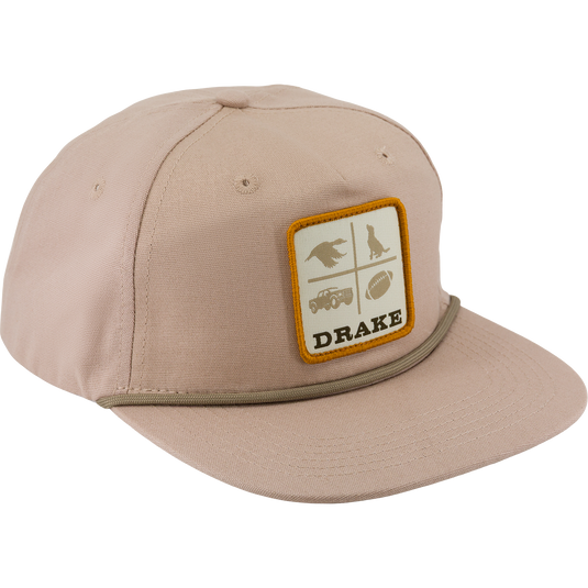 Tan Drake X Lost Hat DDTF Goat Rope Cap with a flat brim, a rope detail above the bill, and a square patch featuring four quadrants with a bird, a dog, a truck, and a football, with the word DRAKE underneath.