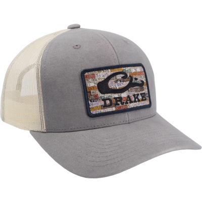Drake License Plate Mesh Back Cap with gray twill front, off-white mesh back, vintage license-plate patch, and adjustable snap closure for comfort.
