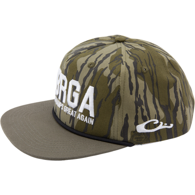 Drake x Lost Hat MBRGA Hybrid Patch Goat Rope Cap featuring camo fabric, flat-brim, white slogan embroidery, and adjustable snap-back closure.