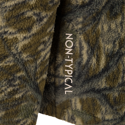 Close-up of Non-Typical Statix Sherpa Fleece Insulated Jacket, highlighting fuzzy texture and partial branding, designed for rugged warmth and mobility in hunting conditions.