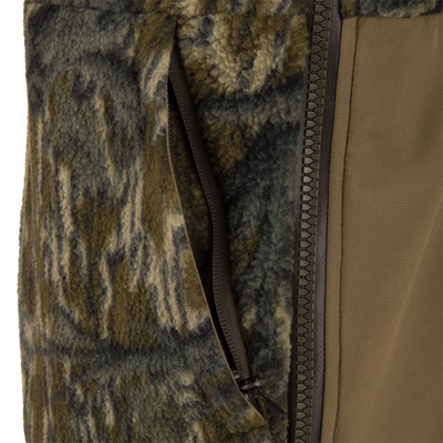 Non-Typical Statix Fleece Lined Bib featuring camo-style sherpa fleece and smooth soft-shell panels with a central zipper and zippered pocket for extreme cold hunting conditions.