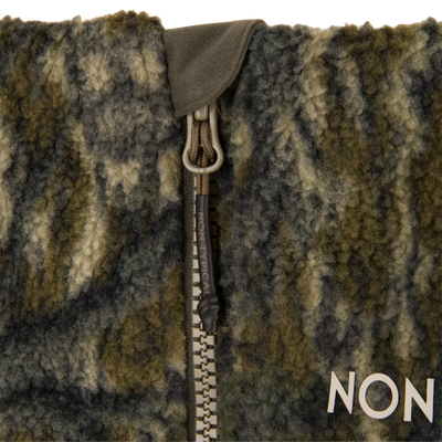 Close-up of Non-Typical Statix Fleece Lined Bib with Agion Active X2 featuring a camouflage-style fleece, sturdy zipper, and paracord pull tab marked NON-TYPICAL.