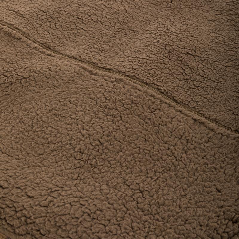 Close-up of the Midweight Nova Silencer Vest's brown Sherpa fleece, highlighting its seam and soft texture, designed for warmth and breathability in outdoor activities.