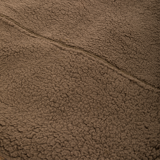 Close-up of the Midweight Nova Silencer Vest's brown Sherpa fleece, highlighting its seam and soft texture, designed for warmth and breathability in outdoor activities.
