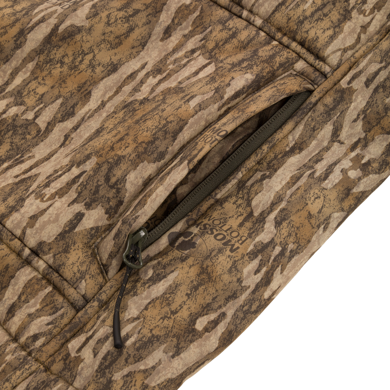 Midweight Nova Silencer Vest with Agion Active X2, showcasing its bottomland camo pattern, Magnattach chest pocket, and durable YKK zipper. Ideal for outdoor enthusiasts.