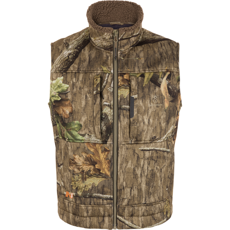 Midweight Nova Silencer Vest with Agion Active X2, featuring woodland camo, fleece-lined collar, zip pockets, quilted panels, and safety harness opening for warmth and concealment.