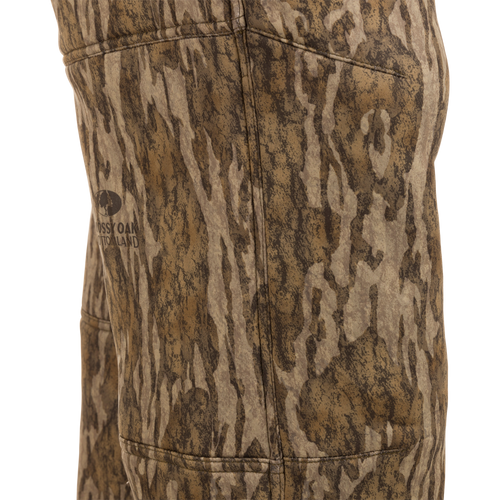 Midweight Nova Silencer Pant with Scent Control featuring Mossy Oak Bottomland pattern, showcasing stitching, pocket outline, and logo, designed for odor protection and water resistance.