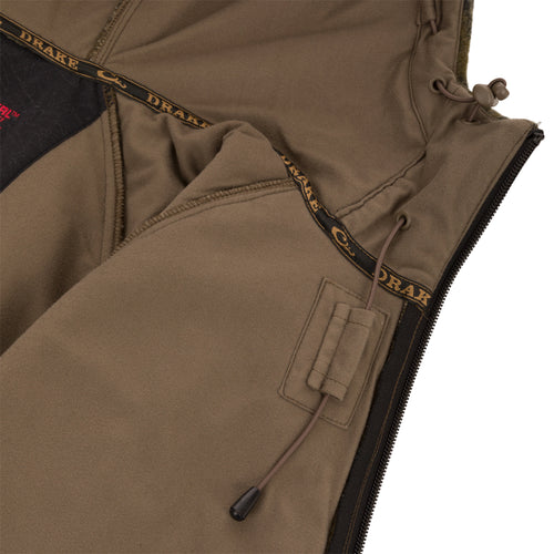 Interior of Midweight Hydrowool Softshell Jacket with Scent Control, showing Drake seam tape, heavy-duty zipper, adjustable drawcord, and internal elastic loop for headphone routing.