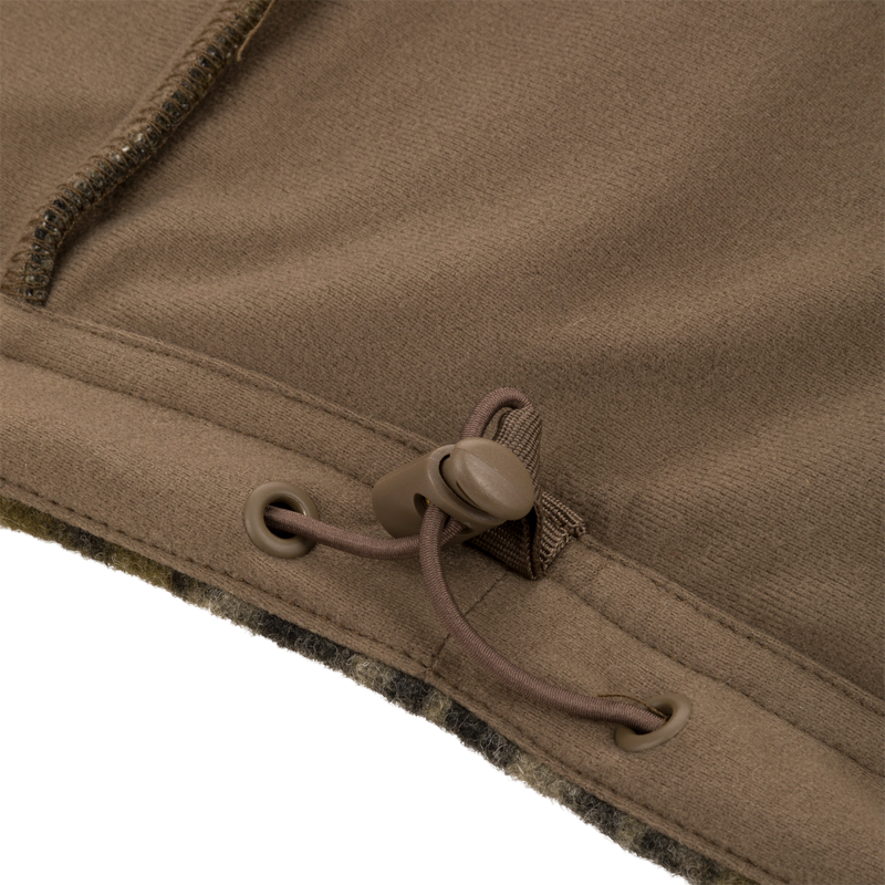 Close-up of Midweight Hydrowool Softshell Jacket hem with drawcord and cord-lock, showcasing windproof, waterproof design for outdoor adventures.