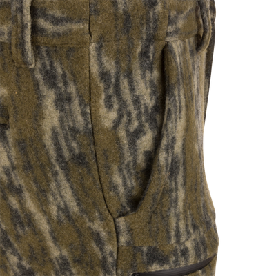 Close-up of Midweight Hydrowool Softshell Pant's hand-warmer pocket, showcasing mottled wool blend fabric with visible zipper, highlighting its utility for outdoor adventures.