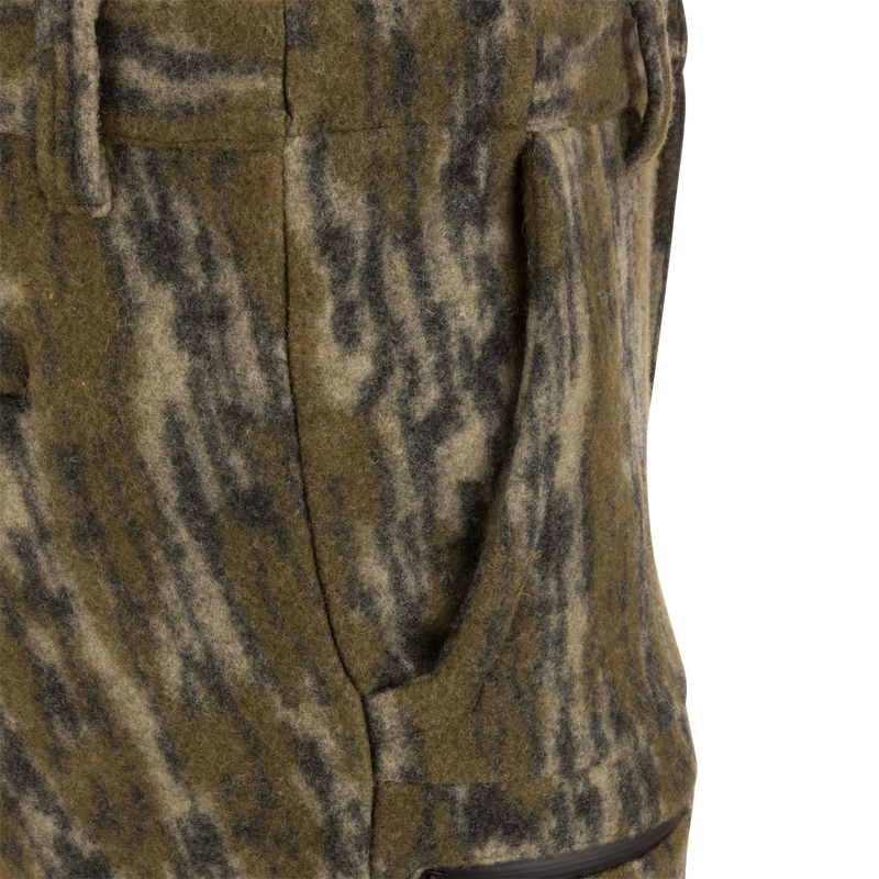 Close-up of Midweight Hydrowool Softshell Pant's hand-warmer pocket, showcasing mottled wool blend fabric with visible zipper, highlighting its utility for outdoor adventures.